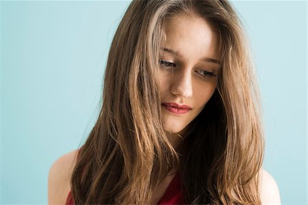 simsearch:700-07567431,k - Close-up portrait of teenage girl looking downwards, studio shot on blue background Foto de stock - Con derechos protegidos, Código: 700-07567436