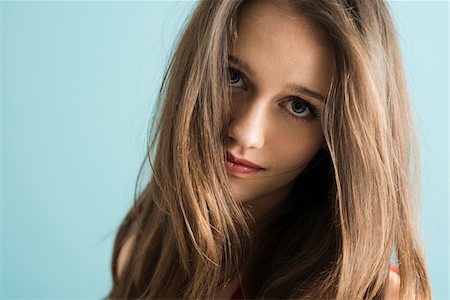 en primer plano - Close-up portrait of teenage girl looking at camera, studio shot on blue background Foto de stock - Con derechos protegidos, Código: 700-07567437