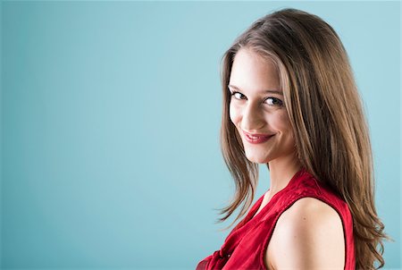 simsearch:600-07584749,k - Close-up portrait of teenage girl looking at camera and smiling, studio shot on blue background Stock Photo - Rights-Managed, Code: 700-07567430