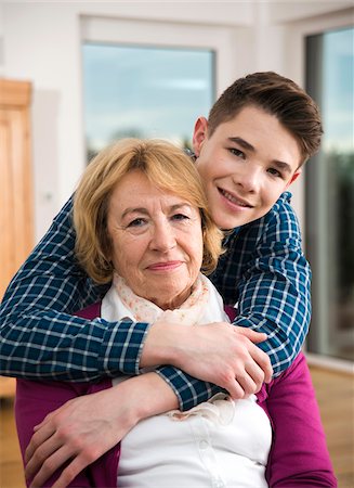 photo of happy family stand front of home - Portrait of teenage grandson with grandmother at home, Germany Stock Photo - Rights-Managed, Code: 700-07584797