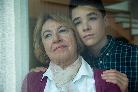 senior family hug portrait thinking - Close-up portrait of teenage grandson with grandmother looking out window together, Germany Stock Photo - Rights-Managed, Code: 700-07584802