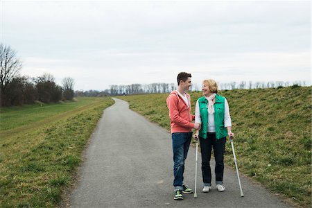 Teenage grandson talking to grandmother using crutches on pathway in park, walking in nature, Germany Stockbilder - Lizenzpflichtiges, Bildnummer: 700-07584831