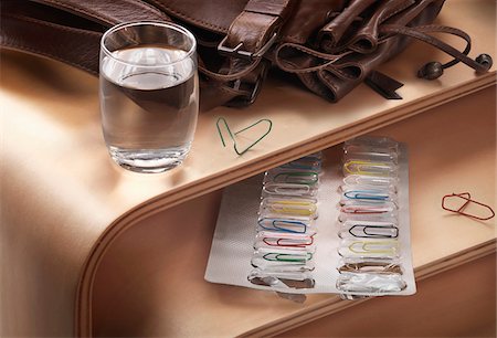 Blister pack with paper clips on desk and glass of water Foto de stock - Con derechos protegidos, Código: 700-07698680