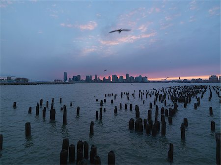 Sunset view of Hudson River with posts from old pier, Lower Manhattan, New York City, New York, USA Stock Photo - Rights-Managed, Code: 700-07698681
