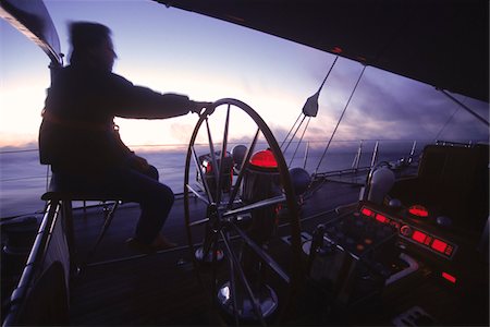 Captain helms Endeavour at Dawn towards Antigua with Navigational Instruments Glowing Red Stock Photo - Rights-Managed, Code: 700-07965845
