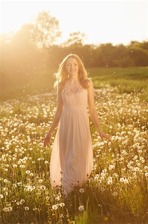 picture of old lady smiling - Young woman standing in a withered dandelion meadow in spring, Germany Stock Photo - Rights-Managed, Code: 700-08080548