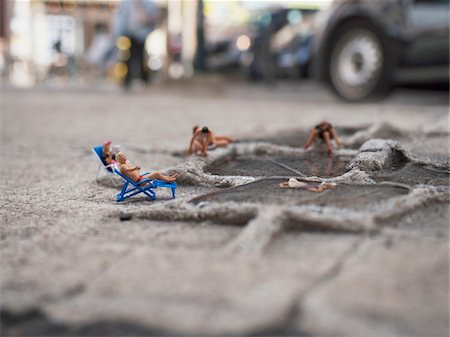 strange scene - Close-up of miniature figures using tire treadmark and water as beach Stock Photo - Rights-Managed, Code: 700-08548007