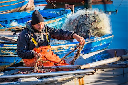 fat male - Fisherman sitting in boat tending his nets at the Old Port of La Cala in Palermo, Sicily in Italy Stock Photo - Rights-Managed, Code: 700-08701889