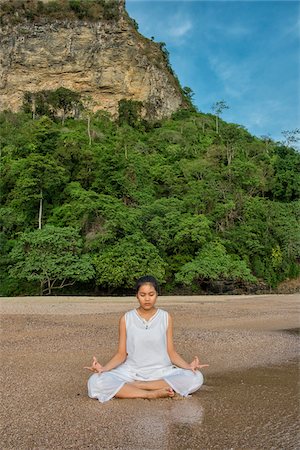 Thai girl sitting in easy pose poition and meditating on beach at Ao Nang in Krabi Thailand. Stock Photo - Rights-Managed, Code: 700-08743676