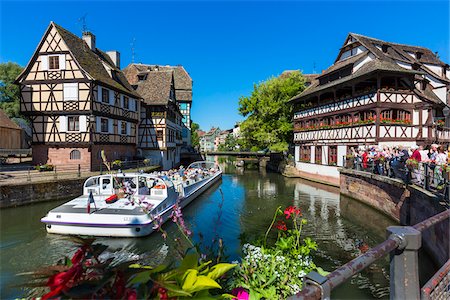 simsearch:700-09052900,k - Tourists standing along the seawall watching a tour boat travelling along the River Ill in the Petite France area in Strasbourg, France Photographie de stock - Rights-Managed, Code: 700-08973555