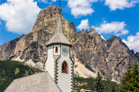 Close-up of the steeple of the St Caterina Parish in the township of Corvara with mountain tops of the Dolomites in the background in South Tyrol, Italy Stock Photo - Rights-Managed, Code: 700-08986588