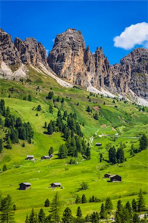 Grassy mountain side with wooden mountain huts and the jagged mountain ridge at the Gardena Pass in the Dolomites in South Tyrol, Italy Foto de stock - Con derechos protegidos, Código: 700-08986583
