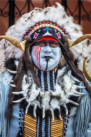 Close-up portrait of a male, indigenous tribal dancer with painted face and wearing a feathered headdress with horns at the St Michael Archangel Festival parade in San Miguel de Allende, Mexico Foto de stock - Con derechos protegidos, Código: 700-09088057