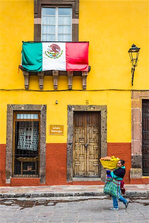 street color buildings - Woman carrying flowers for sale walking down street at the St Michael Archangel Festival in San Miguel de Allende, Mexico Photographie de stock - Rights-Managed, Code: 700-09088113