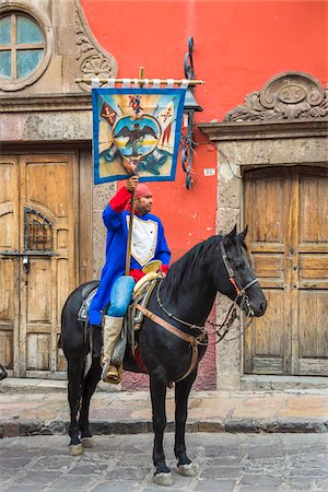 simsearch:700-09088193,k - Man wearing traditiinal clothing riding a horse and holding a flag during the historic horseback parade celebrating Mexican Independence Day, San Miguel de Allende, Mexico. Stock Photo - Rights-Managed, Code: 700-09088187