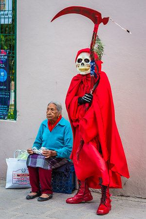 Person in Grim Reaper costume standing beside Mexican woman sitting on sidewalk at a St Michael Archangel Festival parade in San Miguel de Allende, Mexico Stock Photo - Rights-Managed, Code: 700-09227066