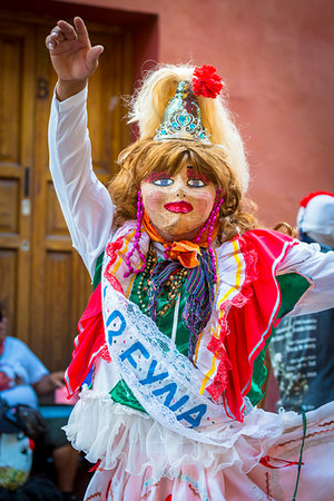 fiesta de san miguel arcangel - Person dressed-up in costume with mask and blond wig dancing in stret at a St Michael Archangel Festival parade in San Miguel de Allende, Mexico Foto de stock - Direito Controlado, Número: 700-09273202