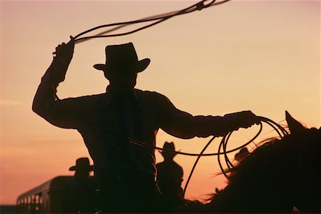 Silhouette of Cowboy with Lasso At Sunset Foto de stock - Con derechos protegidos, Código: 700-00002709