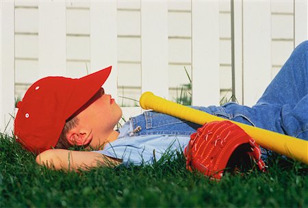 Boy Laying in Grass with Baseball Gear Stock Photo - Rights-Managed, Code: 700-00012871
