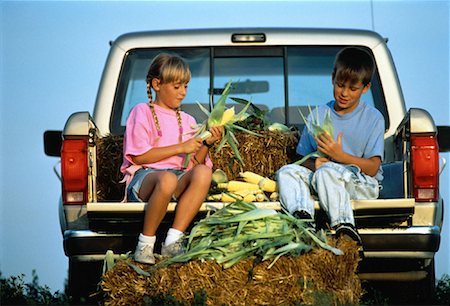 Boy and Girl Husking Corn in Back of Pick-Up Truck Stock Photo - Rights-Managed, Code: 700-00013587