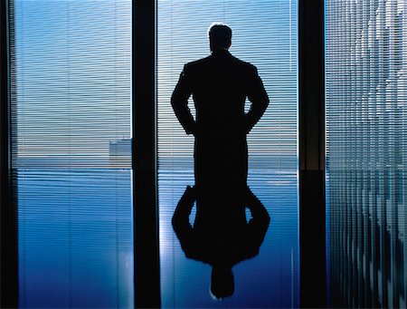 photo of silhouette of man looking through window - Silhouette of Businessman Looking Out of Window Stock Photo - Rights-Managed, Code: 700-00025036