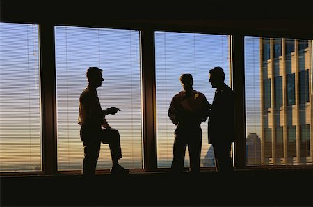 Silhouette d'hommes d'affaires parler dans la salle de conférence Photographie de stock - Rights-Managed, Code: 700-00025072