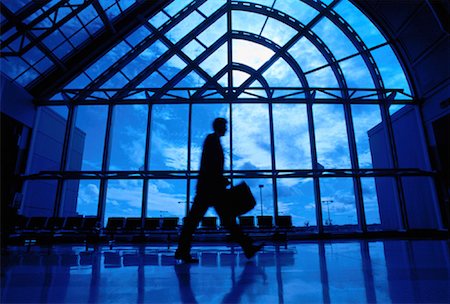 Silhouette of Businessman Walking Near Window in Airport Fotografie stock - Rights-Managed, Codice: 700-00025098