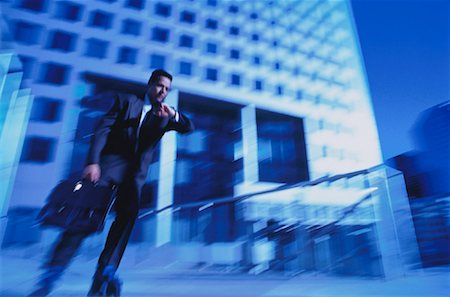 Businessman Wearing In-Line Skates, Checking Watch Outdoors Stock Photo - Rights-Managed, Code: 700-00025167