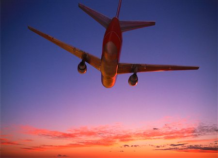 simsearch:700-00197436,k - Regardant vers le haut l'avion en vol au coucher du soleil Photographie de stock - Rights-Managed, Code: 700-00026231