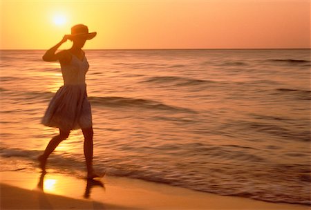 simsearch:700-00091198,k - Silhouette de femme qui marche sur la plage au coucher du soleil Photographie de stock - Rights-Managed, Code: 700-00028524