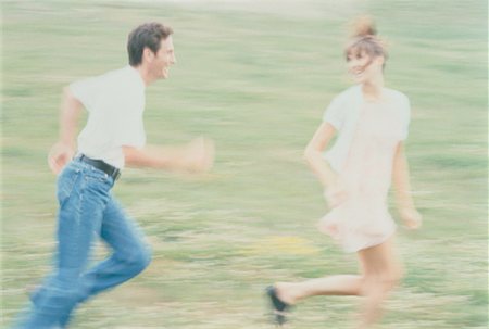 Blurred View of Couple Running In Field Fotografie stock - Rights-Managed, Codice: 700-00029904