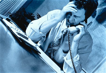 phone with pain - Frustrated Businessman Using Phone at Desk Stock Photo - Rights-Managed, Code: 700-00020433