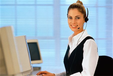 Portrait de femme d'affaires assis devant un ordinateur, à l'aide du casque téléphonique Photographie de stock - Rights-Managed, Code: 700-00020813
