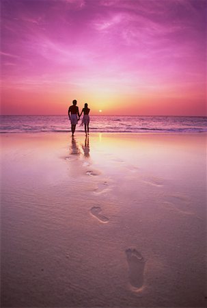 simsearch:700-00038738,k - Silhouette couple marchant sur la plage au coucher du soleil Photographie de stock - Rights-Managed, Code: 700-00021491