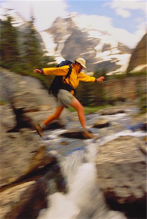 Blurred View of Hiker Crossing Stream Stock Photo - Rights-Managed, Code: 700-00021792