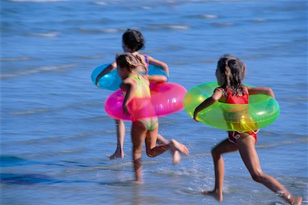 sport running girl tube - Girls in Swimwear, Running on Beach with Inner Tubes Stock Photo - Rights-Managed, Code: 700-00037020