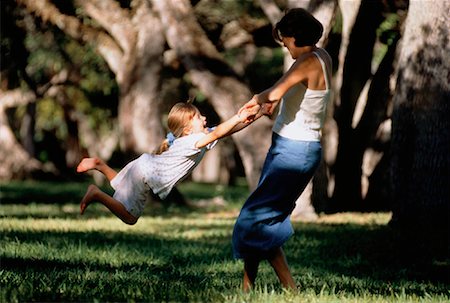 Mother Swinging Daughter by Arms Outdoors Stock Photo - Rights-Managed, Code: 700-00037656