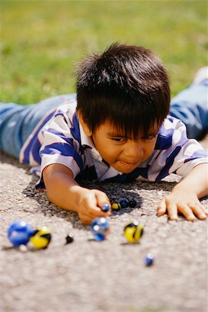 Boy Playing with Marbles Outdoors Stock Photo - Rights-Managed, Code: 700-00037705