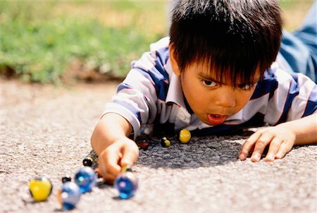 Boy Playing with Marbles Outdoors Stock Photo - Rights-Managed, Code: 700-00037706