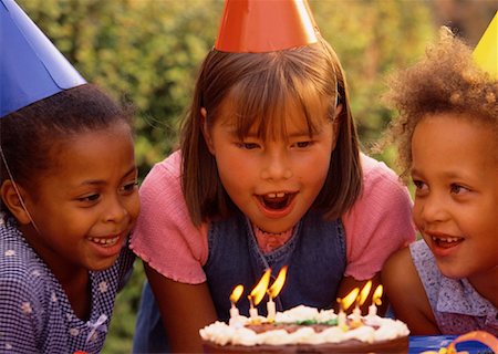 Girl Blowing Out Candles on Cake Outdoors Stock Photo - Rights-Managed, Code: 700-00038297