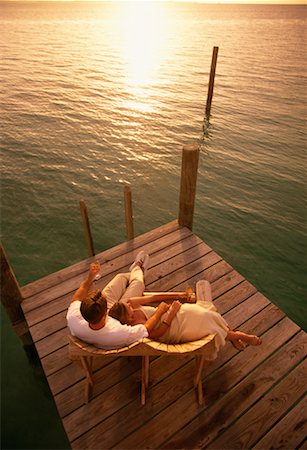 simsearch:700-00038738,k - Vue aérienne du Couple assis dans des chaises longues sur le quai au coucher du soleil Photographie de stock - Rights-Managed, Code: 700-00038734