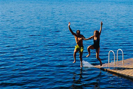 Couple in Swimwear, Jumping into Water from Dock Stock Photo - Rights-Managed, Code: 700-00038866