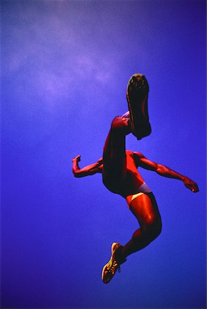 salto em distância - Looking Up at Man Long Jumping Foto de stock - Direito Controlado, Número: 700-00030206