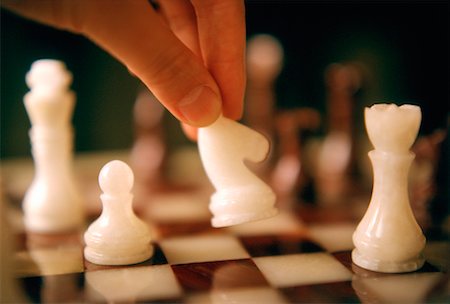 Close-Up of Hand Moving Chess Piece Stock Photo - Rights-Managed, Code: 700-00030271