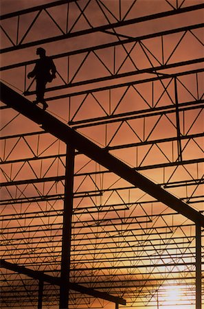 Silhouette du travailleur marcher sur supports en acier au coucher du soleil Photographie de stock - Rights-Managed, Code: 700-00030314