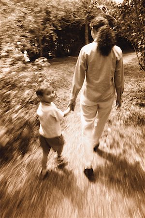 Vue de la mère et son fils marcher à l'extérieur, main dans la main arrière Photographie de stock - Rights-Managed, Code: 700-00031460