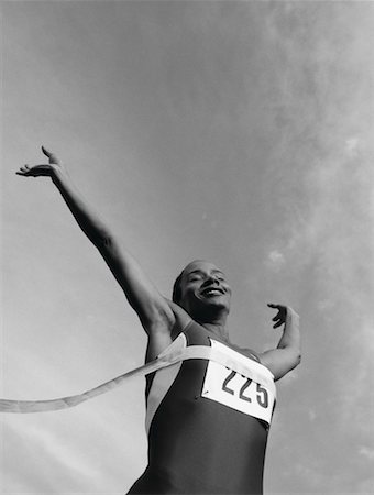 runners crossing the finish line - Female Runner Crossing Finish Line Stock Photo - Rights-Managed, Code: 700-00032762