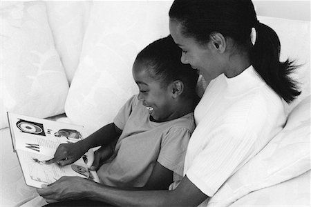 Mother and Daughter Reading Book On Sofa Stock Photo - Rights-Managed, Code: 700-00033316