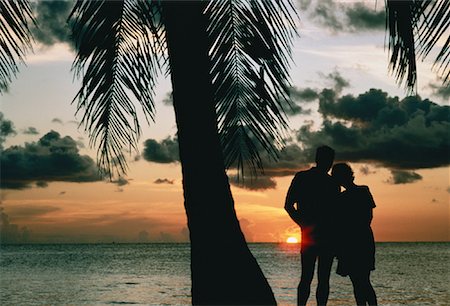 simsearch:700-00152780,k - Silhouette de Couple debout sur la plage près de palmiers au coucher du soleil Photographie de stock - Rights-Managed, Code: 700-00044881