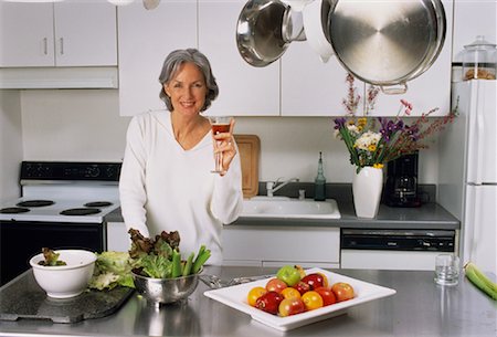 simsearch:700-00343349,k - Portrait of Mature Woman Holding Glass in Kitchen Fotografie stock - Rights-Managed, Codice: 700-00045593